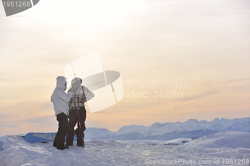 Image of snowboarder's couple on mountain's top