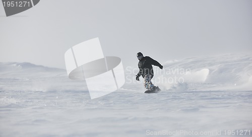 Image of freestyle snowboarder jump and ride
