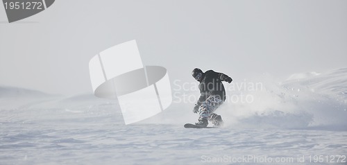 Image of freestyle snowboarder jump and ride