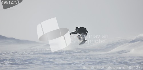 Image of freestyle snowboarder jump and ride