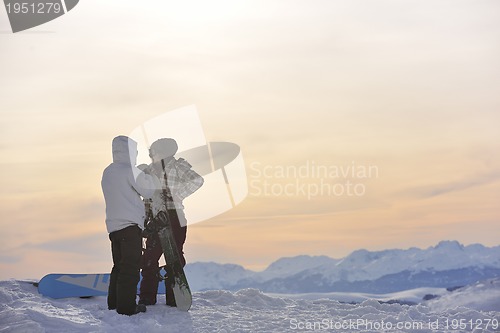 Image of snowboarder's couple on mountain's top