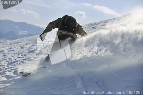 Image of freestyle snowboarder jump and ride