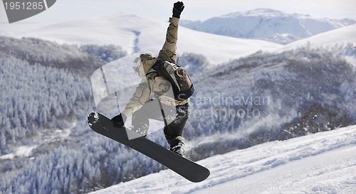 Image of freestyle snowboarder jump and ride