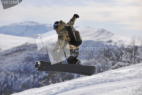 Image of freestyle snowboarder jump and ride