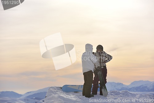 Image of snowboarder's couple on mountain's top