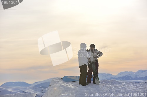 Image of snowboarder's couple on mountain's top