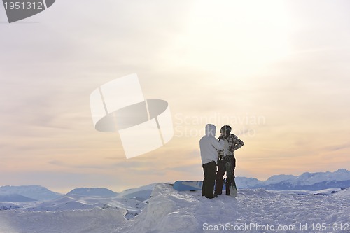 Image of snowboarder's couple on mountain's top