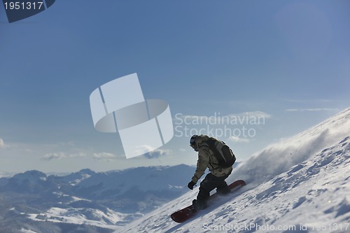 Image of freestyle snowboarder jump and ride