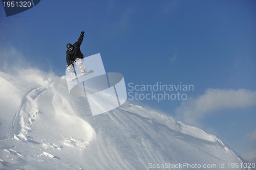 Image of freestyle snowboarder jump and ride