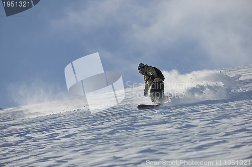 Image of freestyle snowboarder jump and ride