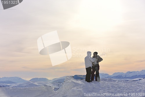 Image of snowboarder's couple on mountain's top