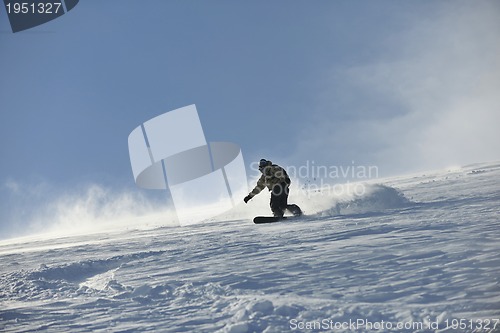 Image of freestyle snowboarder jump and ride