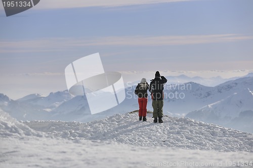 Image of snowboarder's couple on mountain's top