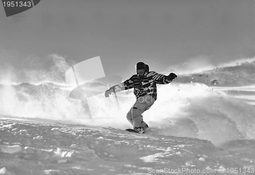 Image of freestyle snowboarder jump and ride