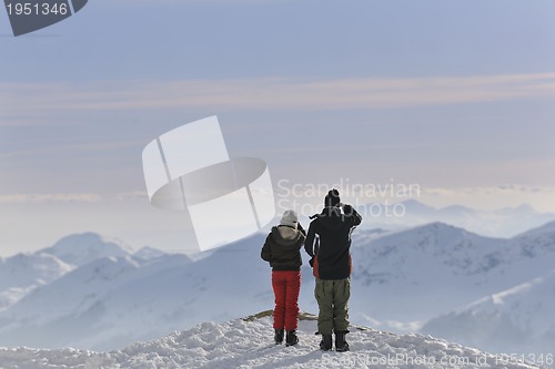 Image of snowboarder's couple on mountain's top