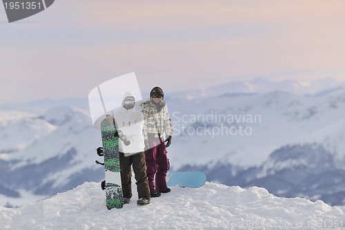 Image of snowboarder's couple on mountain's top