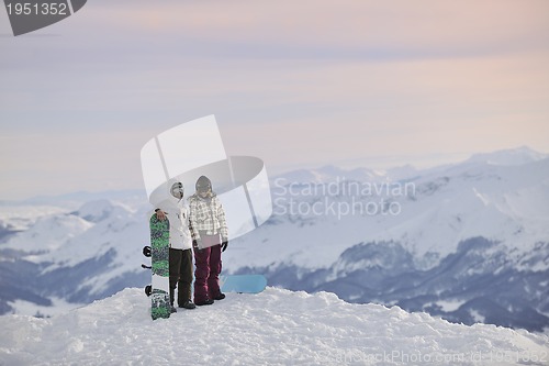 Image of snowboarder's couple on mountain's top