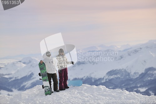 Image of snowboarder's couple on mountain's top