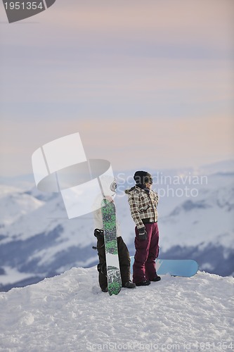 Image of snowboarder's couple on mountain's top