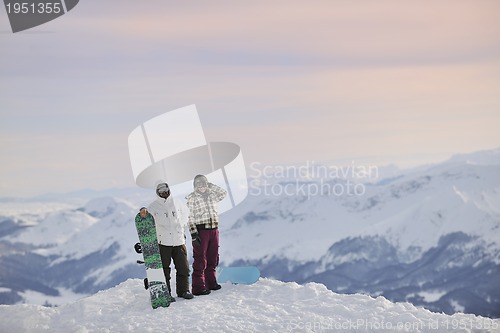 Image of snowboarder's couple on mountain's top