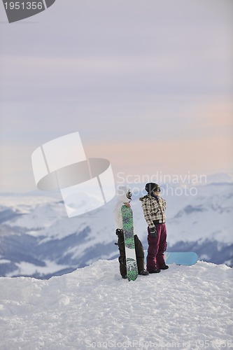 Image of snowboarder's couple on mountain's top