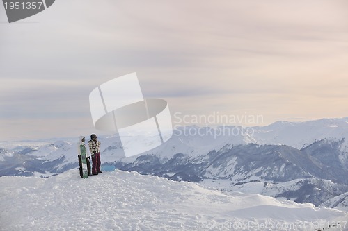 Image of snowboarder's couple on mountain's top