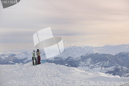 Image of snowboarder's couple on mountain's top