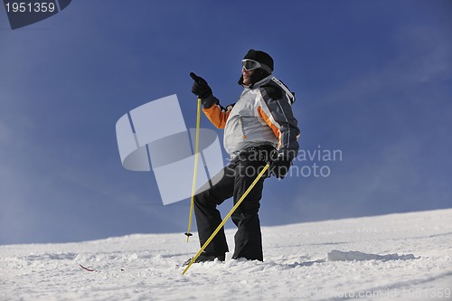 Image of young skier relaxing at beautiful sunny winter day