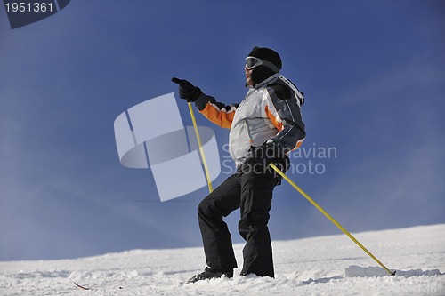 Image of young skier relaxing at beautiful sunny winter day