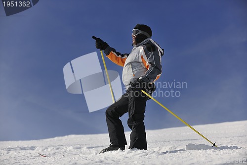 Image of young skier relaxing at beautiful sunny winter day