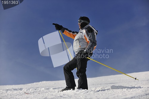 Image of young skier relaxing at beautiful sunny winter day