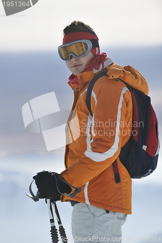 Image of young skier relaxing at beautiful sunny winter day