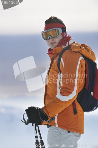 Image of young skier relaxing at beautiful sunny winter day