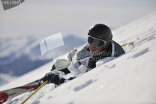 Image of young skier relaxing at beautiful sunny winter day