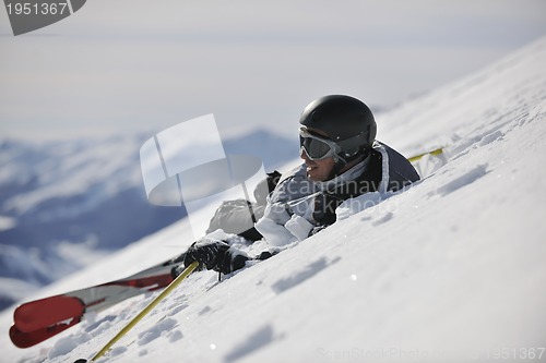 Image of young skier relaxing at beautiful sunny winter day