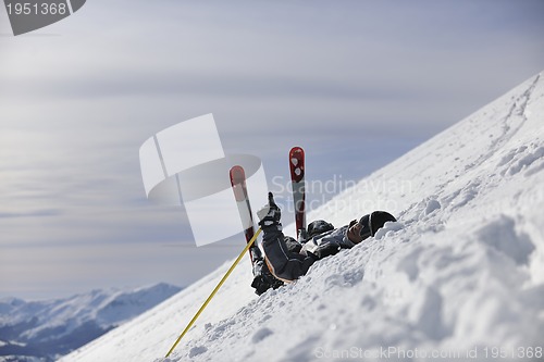 Image of young skier relaxing at beautiful sunny winter day