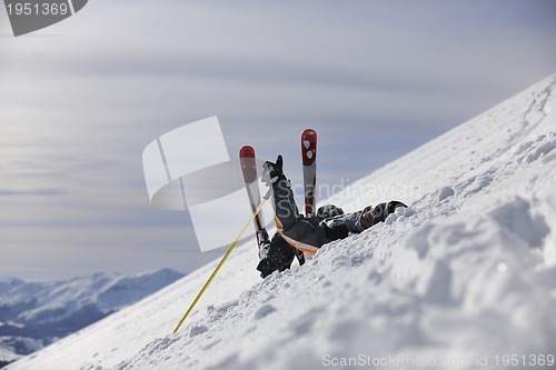 Image of young skier relaxing at beautiful sunny winter day