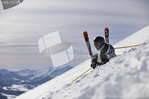 Image of young skier relaxing at beautiful sunny winter day