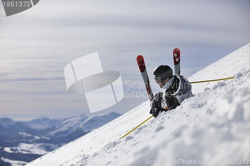 Image of young skier relaxing at beautiful sunny winter day