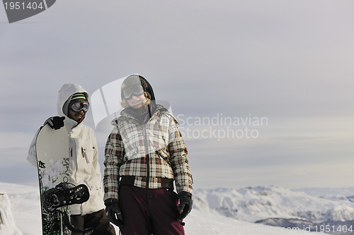 Image of snowboarder's couple on mountain's top