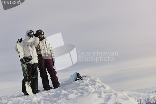 Image of snowboarder's couple on mountain's top