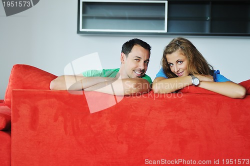 Image of happy couple relax on red sofa 