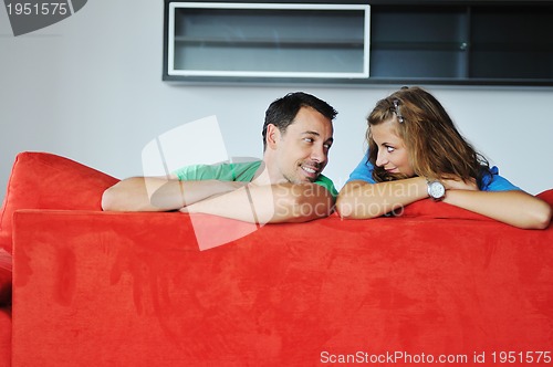 Image of happy couple relax on red sofa 