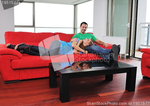 Image of happy couple relax on red sofa