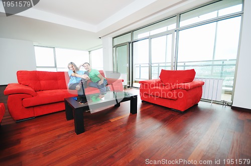 Image of happy couple relax on red sofa 