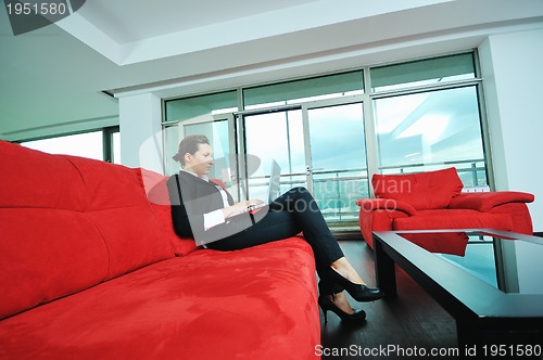 Image of young business woman working on laptop at home