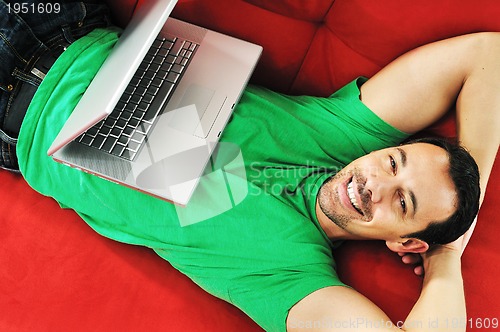 Image of man relaxing on sofa and work on laptop computerman relaxing on