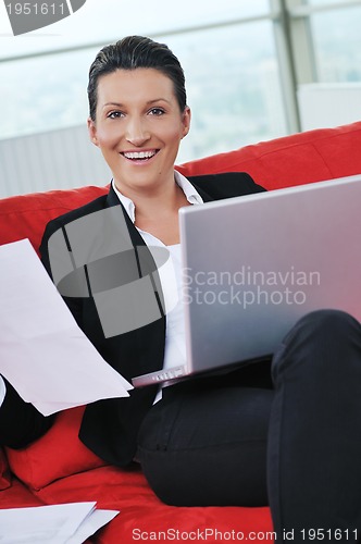 Image of young business woman working on laptop at home