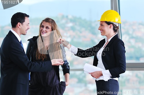 Image of happy young couple buying new home with real estate agent