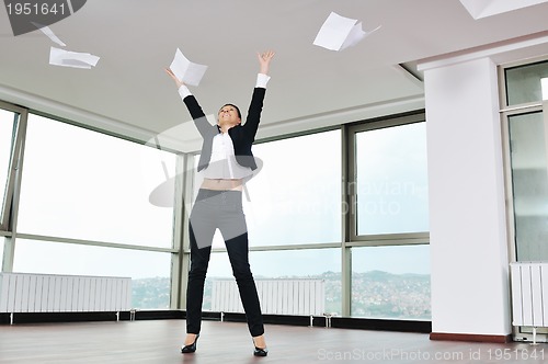 Image of young business woman throw papers in air